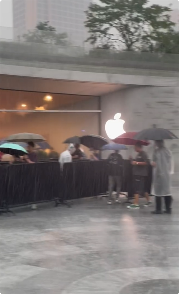 首批iPhone 16用戶收到新機(jī)：果粉暴雨中在Apple Store排長隊取貨
